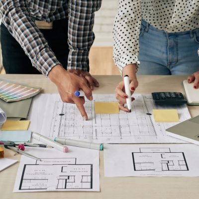 Cropped image of engineers discussing blueprint of the building